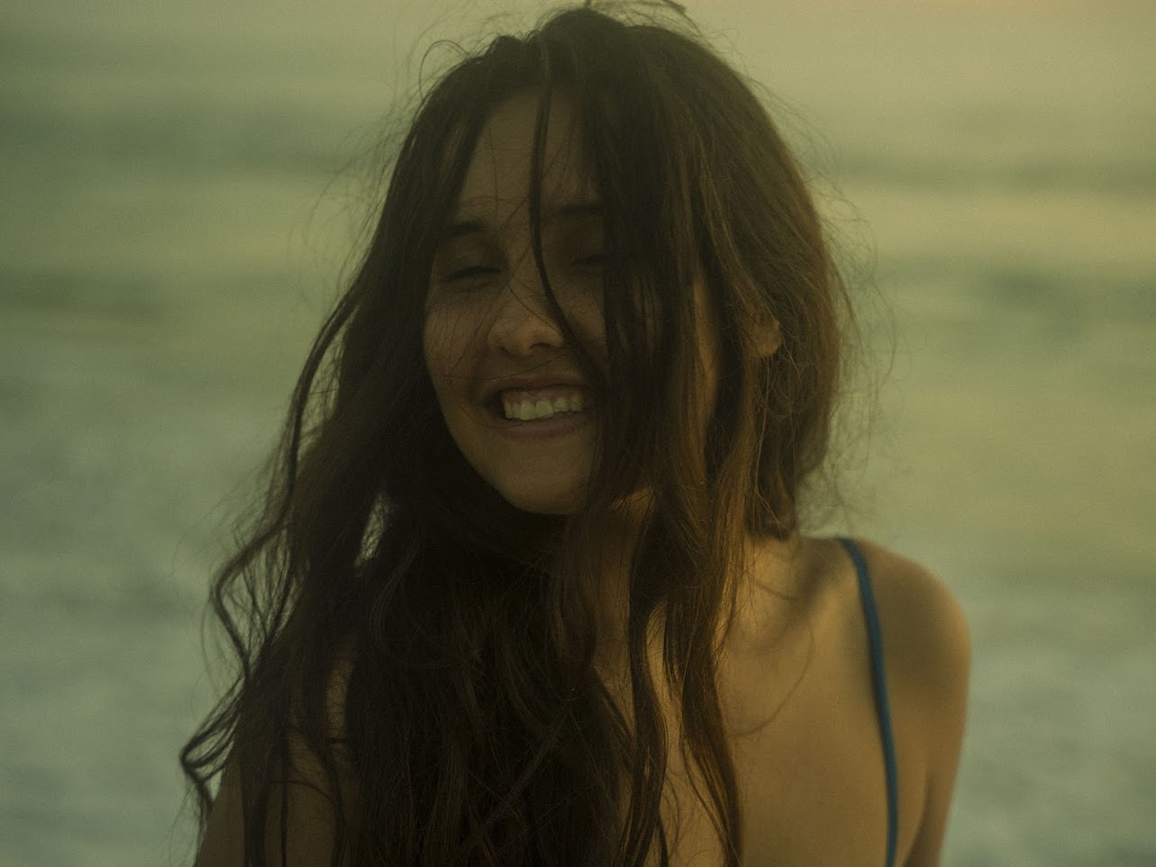 Woman sitting on beach at sunset